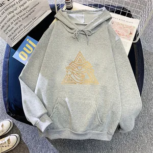 Detailed view of grey oversize hoodie featuring a golden Eye of Horus print and front pocket