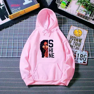 Détail d'un sweat à capuche rose avec texte SHINE, portrait et finitions bord-côte
