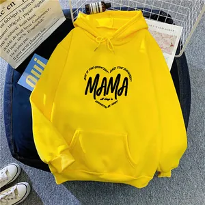 Close-up of bright yellow oversized hoodie with heart print and kangaroo pocket detail