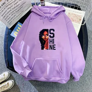 Vue à plat d'un sweat à capuche lilas avec imprimé SHINE et poche kangourou sur fond tendance