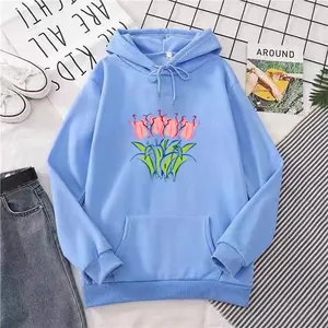 Flat lay of light blue oversized hoodie featuring pink tulip graphic and kangaroo pocket
