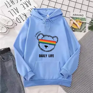 Detail of light blue hoodie featuring rainbow bear graphic and cozy kangaroo pocket
