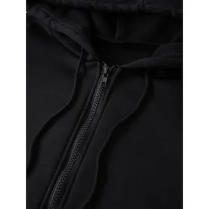 Close-up of black oversized zip-up hoodie featuring a durable plastic zipper and drawstrings
