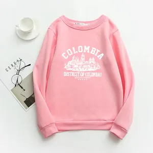 Flat lay of pink crewneck sweatshirt with retro Colombia print and lifestyle props