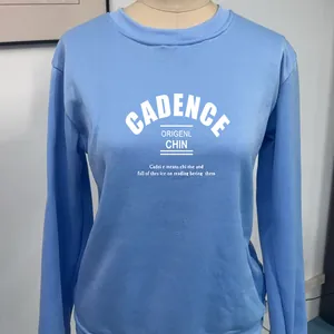 Detail of light blue crewneck sweatshirt featuring white CADENCE letter print