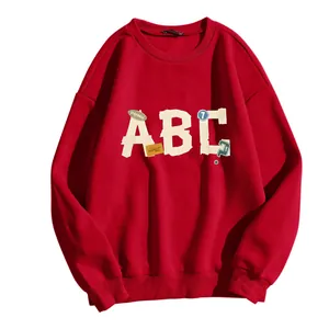 Détail du sweat à col rond rouge avec imprimé lettres ABC vintage et épaules tombantes
