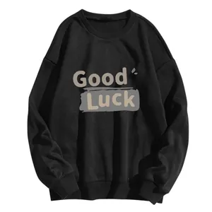 Détail de l'imprimé Good Luck et trait artistique sur un sweat noir à col rond ample