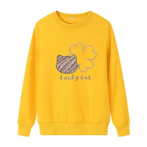 Detail of a bright yellow sweatshirt featuring a cute lucky cat and floral chest print