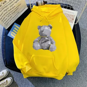 Close-up of a yellow hoodie featuring a geometric bear print and a front kangaroo pocket