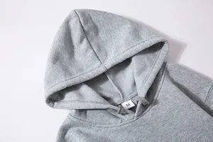 Details van grijze hoodie met trekkoord en fleece textuur met maatlabel M erop