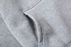 Macro-detail van de grijze hoodie-stof met naden en de textuur van de kangoeroezak