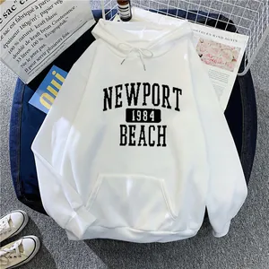 Détail à plat du sweat à capuche blanc avec imprimé Newport 1984 Beach et poche kangourou