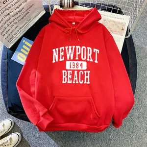 Détail du sweat à capuche rouge oversize avec imprimé Newport 1984 et poche kangourou