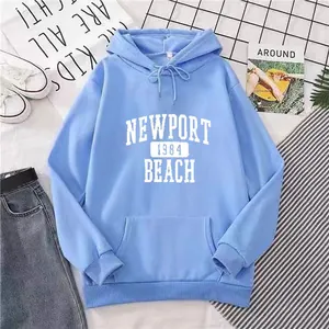 Détail du sweat à capuche bleu clair oversize avec texte Newport 1984 Beach et poche