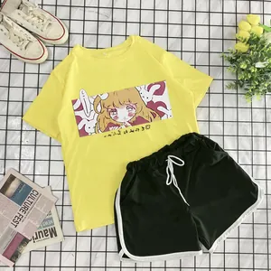 Flat lay of yellow anime print T-shirt and black shorts with side stripes and sneakers