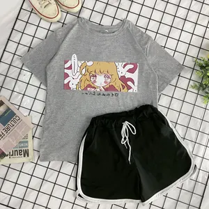 Flat lay of gray anime print T-shirt and black shorts with white drawstrings detail