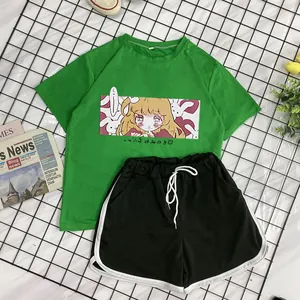 Detail of green manga T-shirt and black shorts sports set for girls on a grid background