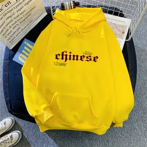Détail du sweat à capuche jaune avec imprimé gothique, poche kangourou et bords-côtes