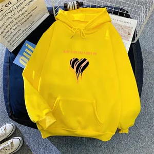 Detail of yellow fleece hoodie featuring zebra heart print and kangaroo pocket flat lay
