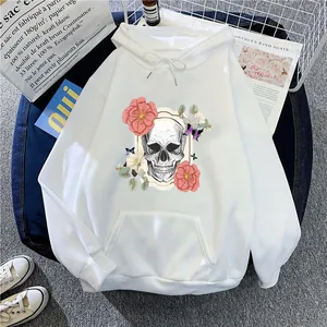 Detail of white hoodie with skull and floral print on denim background with props