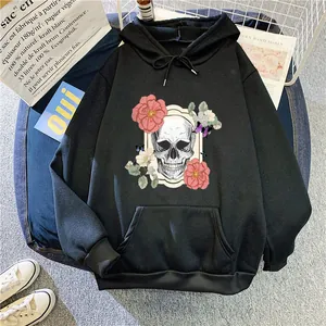 Close-up of black drawstring hoodie featuring skull and pink floral graphic on blue stool