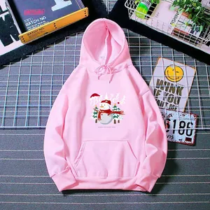 Pink fleece hoodie with snowman print and Believe lettering on a flat lay background