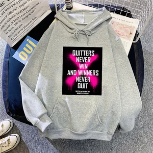 Détail d'un sweat à capuche gris oversize avec imprimé motivant et poche kangourou