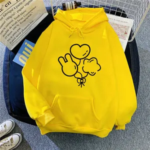Detailed view of yellow hoodie featuring a black line art cartoon balloon print