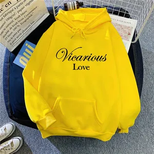 Detail of a bright yellow hoodie featuring black Vicarious Love text and kangaroo pocket
