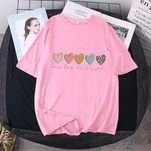 Flat lay of pink cotton T-shirt with heart prints and One Day At A Time slogan