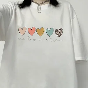 Detail of white cotton T-shirt featuring colorful hearts and one day at a time text