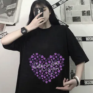 Détail de l'imprimé cœur trèfle violet et texte artistique sur un T-shirt noir ample