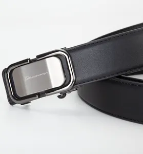 Macro shot of men's leather belt featuring a brushed silver metal automatic buckle