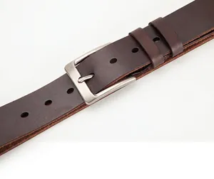 Detail of dark brown leather belt showing matte silver pin buckle and stitching
