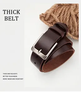 Macro shot of thick brown leather belt with solid silver buckle and vintage texture