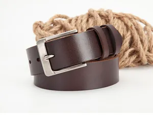 Detail of dark brown leather belt with silver buckle and rustic hemp rope decor