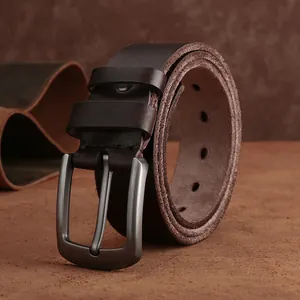 Détail d'une ceinture en cuir marron avec boucle en métal foncé et grain fin