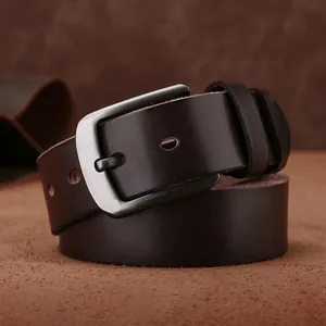 Gros plan sur une ceinture vintage en cuir de vachette marron avec boucle argentée brossée