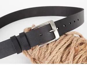 Close-up of black leather belt with silver metal pin buckle on natural hemp rope