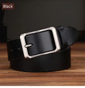 Detail of black leather belt with matte silver pin buckle on rustic wood surface