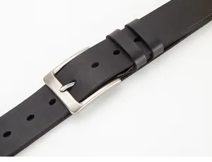 Close-up of men's black leather belt with matte silver buckle and subtle texture