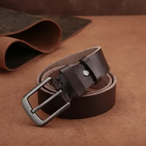 Gros plan sur la boucle en métal brossé et ceinture en cuir marron au design classique