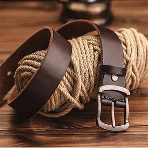 Detailed view of dark brown leather belt with brushed metal buckle on rustic background