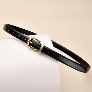 Klassischer Damen-Ledergürtel in Schwarz mit goldener Hufeisenschnalle auf weißem Sockel