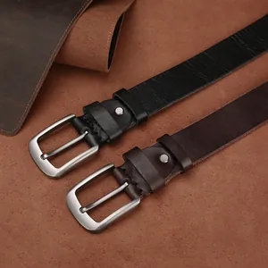 Gros plan détaillé des boucles argentées mates sur des ceintures en cuir noir et marron