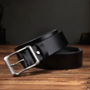 Cintura classica da uomo in vera pelle con fibbia ad ardiglione argento su sfondo in legno