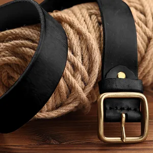 Ceinture classique en cuir noir pour homme avec boucle en laiton vintage sur bois