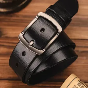 Classic men's black genuine leather belt with matte silver buckle on wooden background