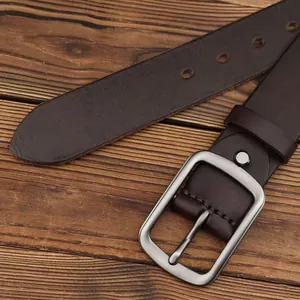 Cintura classica in pelle marrone scuro con fibbia argento opaco su sfondo di legno rustico