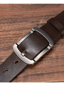 Detailed macro view of dark brown lychee grain leather belt with brushed metal pin buckle